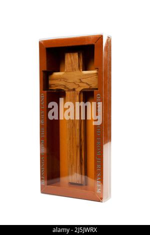 Crucifix en bois debout dans une boîte sur fond blanc Banque D'Images