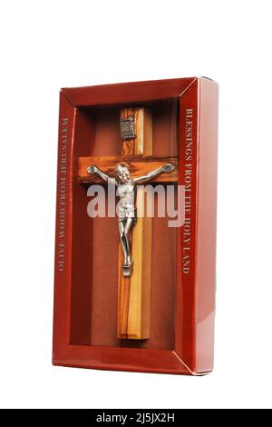 Crucifix en bois debout dans une boîte sur fond blanc Banque D'Images