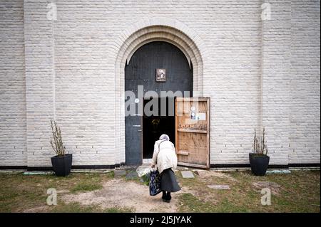 Milmersdorf, Allemagne. 24th avril 2022. Une femme s'arque à l'entrée du monastère orthodoxe russe de Saint-Georges avant les Pâques orthodoxes. Vingt et un réfugiés de la guerre en Ukraine ont maintenant trouvé une résidence temporaire au monastère Saint-Georges de l'Église orthodoxe russe dans la région d'Uckermark, dans le Brandebourg. Credit: Fabian Sommer/dpa/Alay Live News Banque D'Images