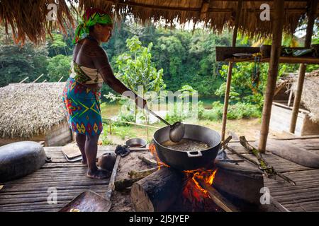 Une femme indienne Embera puru friture de la plantain à l'intérieur du village d'Embera puru, Rio Pequeni, République du Panama, Amérique centrale. Banque D'Images