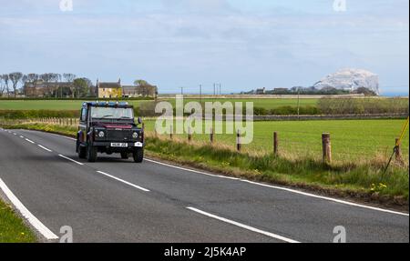 North Berwick, East Lothian, Écosse, Royaume-Uni, 24th avril 2022. Visite en voiture classique : le rassemblement annuel de financement caritatif du North Berwick Rotary Club a lieu sur un parcours de 135 kilomètres à travers East Lothian et les frontières écossaises. Photo : un Land Rover Defender 2000 sur la route côtière près de Bass Rock Banque D'Images