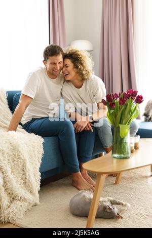 Un couple de caucasiens heureux et leurs chats adorables à la maison Banque D'Images