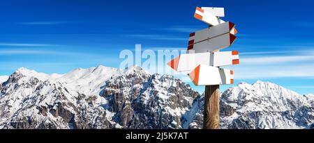 Groupe de panneaux de sentiers directionnels vierges avec des sommets enneigés sur le fond et l'espace de copie. Alpes italiennes, Dolomites, Europe. Banque D'Images