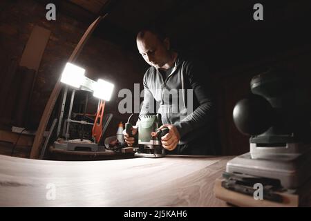 Menuisier avec machine à router électrique à main au travail Banque D'Images