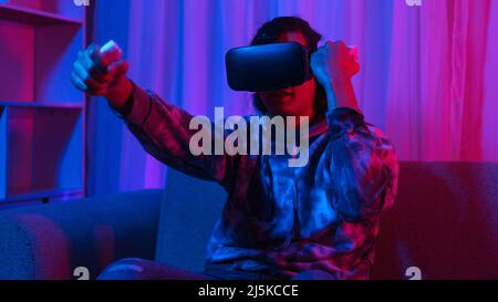Concept de technologie métaverse, Homme porte des lunettes VR et amusez-vous à jouer au jeu de boxe dans le monde virtuel. Banque D'Images