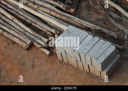 Vue depuis un petit chantier de construction où le tas de briques et de poteaux en bois pour échafaudage sont conservés sur le sol Banque D'Images