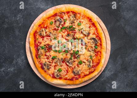 Pizza aux légumes, au fromage et aux herbes fraîches sur fond noir. Pizza végétarienne. Vue de dessus, gros plan. Banque D'Images