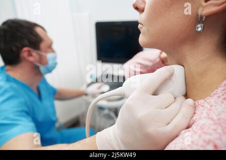 Jeune femme subissant un examen de la glande thyroïde à l'endocrinolodiste Banque D'Images