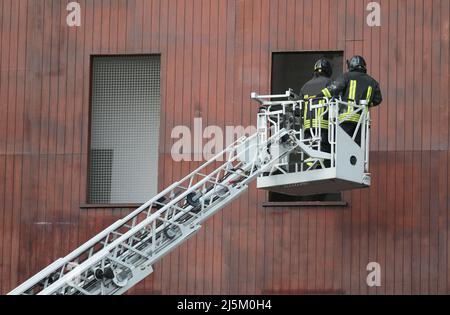 pompier en action dans la caserne de pompiers avec le panier du chariot d'échelle pour accéder de la fenêtre Banque D'Images