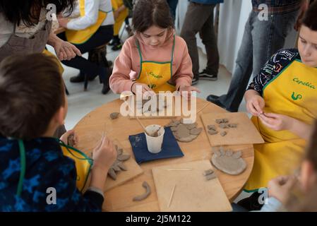 Varsovie, Pologne, Pologne. 24th avril 2022. Les enfants font des sculptures de tournesol à partir d'argile le 24 avril 2022 à Varsovie, Pologne. Quelques dizaines d'Ukrainiens et de Polonais ont pris part à un déjeuner d'intégration de Pâques organisé par le producteur polonais de céramique Cepelia (Acronyme pour le siège de l'industrie folklorique et artistique) et activiste du COLLECTIF STUS à l'occasion du dimanche orthodoxe de Pâques, Dans le but d'intégrer la communauté polonaise et ukrainienne à Varsovie, en Pologne. Un atelier d'argile pour les enfants a suivi le déjeuner. (Image de crédit : © Aleksander Kalka/ZUMA Press Wire) Banque D'Images