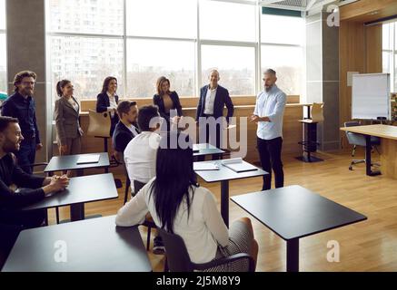 Équipe d'employés se rencontrant au bureau et ayant un cours de formation avec un professeur d'affaires Banque D'Images
