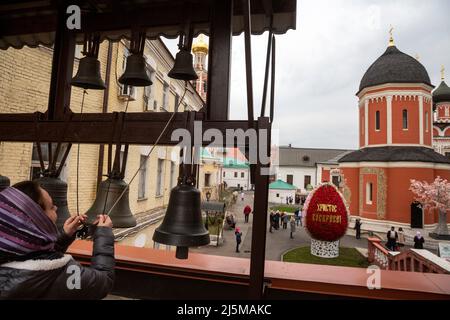 Moscou, Russie. 24th avril 2022. Une femme joue des cloches sur le beffroi du monastère de Vysokopetrovsky lors de la célébration du jour de Pâques à Moscou, en Russie Banque D'Images