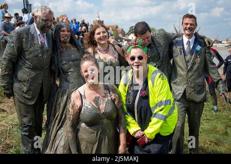 Le comédien JO Brand posant avec une fête de mariage qui venait de terminer la Maldon Mud Race dans leur tenue de mariage complète. Mariée et marié sur la gauche Banque D'Images