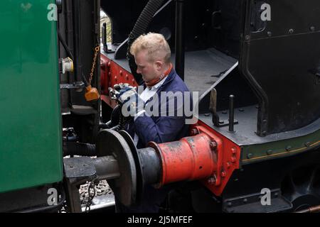 Un mécanicien dételage la locomotive à vapeur 30925 de ses wagons sur le train push-pull qui court sur la ligne de Watercress. Hampshire, Angleterre Banque D'Images