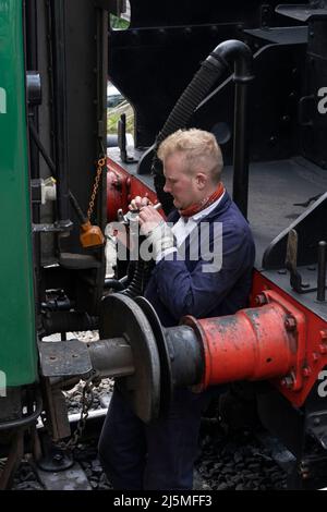 Un mécanicien dételage la locomotive à vapeur 30925 de ses wagons sur le train push-pull qui court sur la ligne de Watercress. Hampshire, Angleterre Banque D'Images