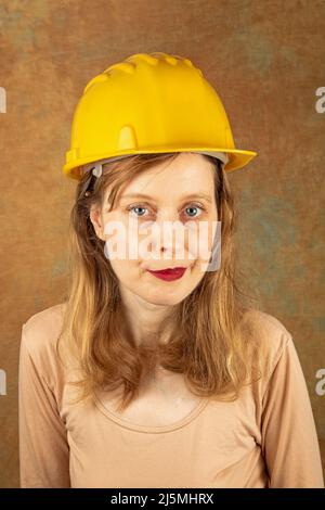 Jeune belle femme travaillant dans l'industrie de la construction portant un casque de protection Banque D'Images