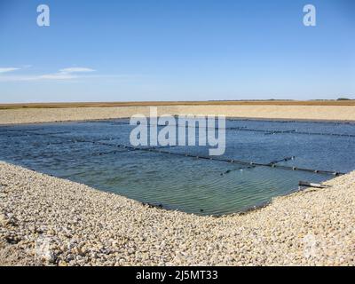 Installation de conduites d'aération pour les bulles fines dans un projet de construction de lagune de traitement aérobie des eaux usées. Banque D'Images