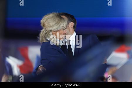 Paris, France. 24th avril 2022. Le président sortant français Emmanuel Macron embrasse sa femme Brigitte Macron lors d'un rassemblement après le second tour de la présidence à Paris, en France, le 24 avril 2022. Le président sortant français Emmanuel Macron a remporté le deuxième tour de l'élection présidentielle française de 2022 avec 58 pour cent des voix, selon le vote de sortie préliminaire publié dimanche soir par la télévision française BFMTV. Marine le Pen, la rivale de Macron, candidate d'extrême droite, a remporté 42 pour cent des voix. Credit: Gao Jing/Xinhua/Alamy Live News Banque D'Images