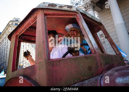 Buenos Aires, Argentine. 23rd avril 2022. Un producteur rural à l'intérieur de son tracteur est accompagné d'une femme habillée dans les couleurs du drapeau argentin lorsqu'il entre sur la place Mayo. Les tracteurs des producteurs ruraux argentins ont été mobilisés vers la place Mayo, à Buenos Aires, pour protester contre la pression fiscale que la campagne Argentine consomme et contre l'intervention du gouvernement national sur le marché des céréales et de la viande. Crédit : SOPA Images Limited/Alamy Live News Banque D'Images