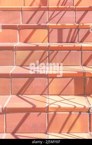 Escaliers avec des briques orange de pêche et des filets à San Francisco, Californie. Gros plan d'un escalier carrelé avec des tons d'orang multicolores Banque D'Images