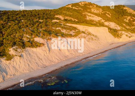 Vue aérienne sur la côte avec falaise, arbres et mer tranquille. Côte aux couleurs du coucher du soleil Banque D'Images