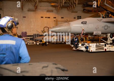 Les marins affectés à l'USS Gerald R. Ford (CVN 78) déplacent le F/A-18E Super Hornet, attaché aux 'Golden Warriorss' de l'escadron de chasseurs de grève (VFA) 87, dans la baie hangar, le 14 avril 2022. Ford est en cours dans l’océan Atlantique en menant des qualifications de transporteur et l’intégration du groupe de grève dans le cadre de la phase de base sur mesure du navire avant le déploiement opérationnel. (É.-U. Photo de la marine par le spécialiste des communications de masse 3rd classe Jacob Mattly) Banque D'Images