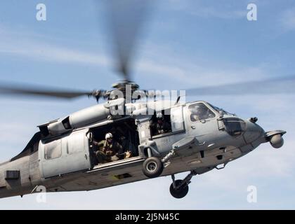 220423-N-LZ839-1063 NORFOLK, VIRGINIE. (Le 23 avril 2022) - un hélicoptère MH-60s affecté au Chargers of Helicopter Sea combat Squadron (HSC) 26 atterrit sur le pont de vol du navire d'assaut amphibie USS Bataan (LHD 5), le 21 avril 2022. Bataan est en cours dans la zone d'exploitation de la flotte de 2nd. Bataan est à la base navale de Norfolk. (É.-U. Photo de la marine par le spécialiste des communications de masse 3rd classe Darren Newell) Banque D'Images