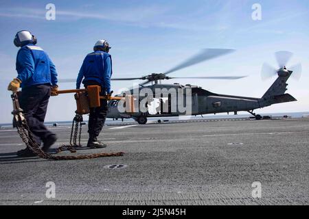 220423-N-LZ839-1355 NORFOLK, VIRGINIE. (Le 23 avril 2022) - des marins affectés au navire d'assaut amphibie USS Bataan (LHD 5) ont sécurisé un hélicoptère MH-60s affecté à l'escadron de combat de la mer (HSC) 26 de Chargers of Helicopters au pont de vol pendant les opérations de vol, le 23 avril 2022. Bataan est en cours dans la zone d'exploitation de la flotte de 2nd. Bataan est à la base navale de Norfolk. (É.-U. Photo de la marine par le spécialiste des communications de masse 3rd classe Darren Newell) Banque D'Images