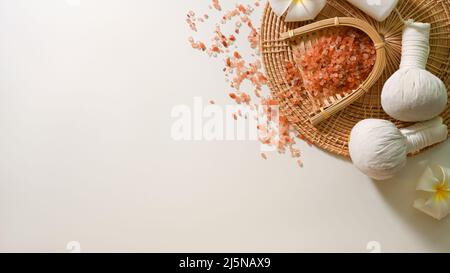 Massage spa d'aromathérapie avec sel rose biologique, balles de massage, fleurs frangipani et espace de copie sur fond blanc. Vue du dessus Banque D'Images