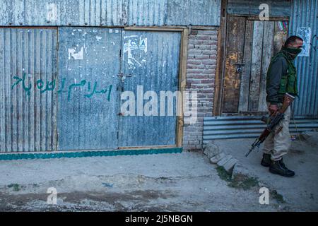 Srinagar, Inde. 23rd avril 2022. Un policier indien se tient sur la garde près du site de la bataille de Pahoo Pulwama. Lashkar e Toiba, commandant adjoint parmi trois militants, a été tué dans un combat par balle dans le district de Pulwama et l'un d'entre eux comprend un jeune Srinagar de 17 ans, qui a disparu le 16 avril, ont déclaré des responsables de la police à l'agence de presse locale. (Photo de Faisal Bashir/SOPA Images/Sipa USA) crédit: SIPA USA/Alay Live News Banque D'Images