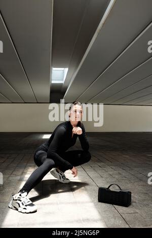 Danseuse urbaine souriante se danseuse de la musique dans un haut-parleur portable Banque D'Images