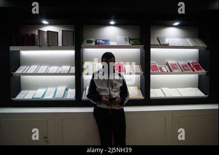 Bogota, Colombie. 24th avril 2022. Un homme voit son téléphone tout en s'inclinant sur un affichage de livre pendant le premier dimanche de la Foire internationale du livre de Bogota 'FILBO' à Bogota, Colombie, le 24 avril 2022. Photo de: CHEPA Beltran/long Visual Press crédit: Long Visual Press/Alay Live News Banque D'Images