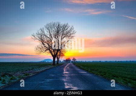 Célèbre RIP Mountain, colline emblématique de la République tchèque. Sur la route asphaltée au milieu des champs à un incroyable lever de soleil dans les Highlands de Bohême centrale, République tchèque. Banque D'Images