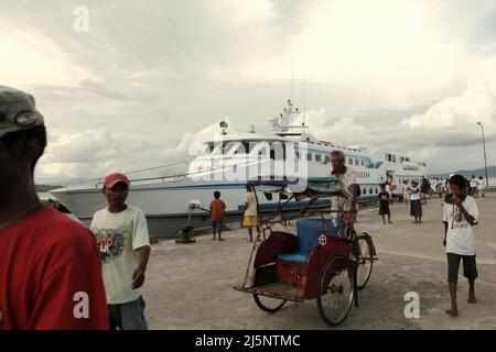 Un chauffeur de becak (pousse-pousse à pédale) à la recherche de passagers au port de ferry d'Ambon à Ambon, dans le centre de Maluku, à Maluku, en Indonésie. Banque D'Images