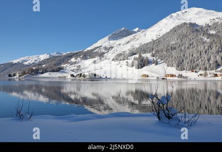 Vue panoramique de beaux paysages Winter Wonderland blanc dans les Alpes avec les sommets de montagne enneigées reflétant dans crystal clear mountain lake sur un col Banque D'Images