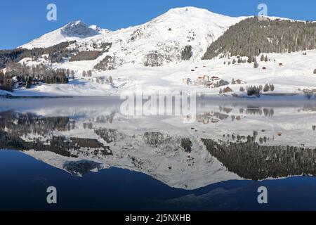 Vue panoramique de beaux paysages Winter Wonderland blanc dans les Alpes avec les sommets de montagne enneigées reflétant dans crystal clear mountain lake sur un col Banque D'Images