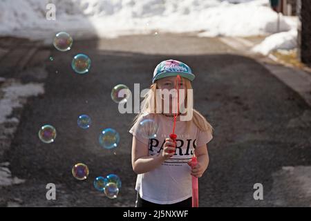 Umea, Norrland Suède - 18 avril 2022 : une petite fille souffle des bulles de savon Banque D'Images