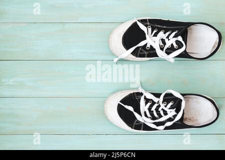 Baskets pour enfant sur une ancienne surface en bois. Chaussures de sport Banque D'Images