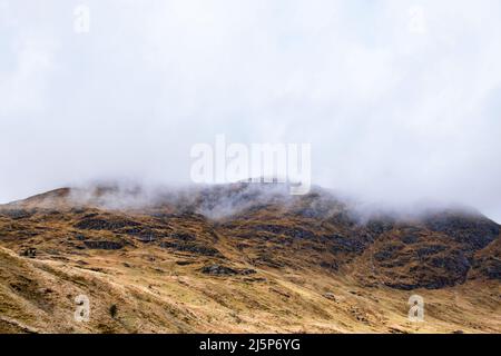 Des nuages bas flottant au-dessus du paysage montagneux des Highlands, des paysages étonnants avec des sommets arides, des pentes abruptes et de petites cascades, l'Écosse Banque D'Images