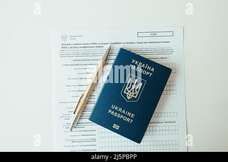 Document PESEL, passeport ukrainien et stylo sur fond de table blanc. Banque D'Images