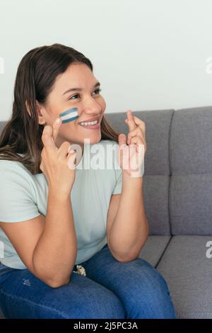 Une femme Argentine a regardé le match de football avec de la peinture pour le visage sur son visage Banque D'Images