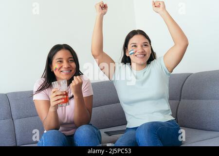 Des amies latino-américaines regardant un match de football à la maison Banque D'Images