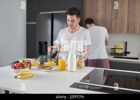 Homme versant du café dans une tasse. Banque D'Images