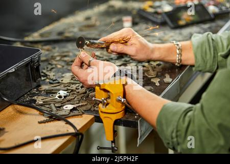 Le serrurier de l'atelier fabrique une nouvelle clé, utiliser une machine à meuler la gravure Banque D'Images