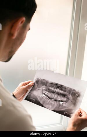 Dentiste à la recherche d'une radiographie des dents de la mâchoire avec une dent implantée . Concept des services de dentiste Banque D'Images