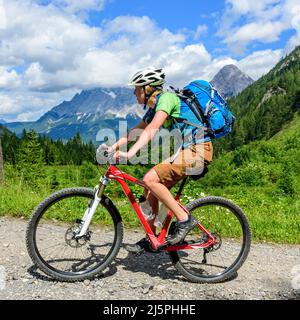 Jeune femme avec ascendant mountainbike sur gravier Banque D'Images