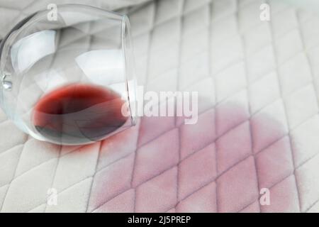 un verre de vin renversé sur la nappe.Nettoyer les vêtements et les meubles des taches Banque D'Images