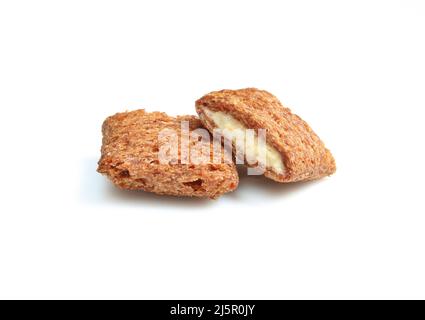 Oreillers croquants de chocolat remplis de crème laiteuse isolés sur fond blanc. Gâteries mordues Banque D'Images