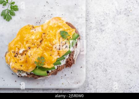 Œufs brouillés avec avocat et fromage à la crème sur pain grillé Banque D'Images