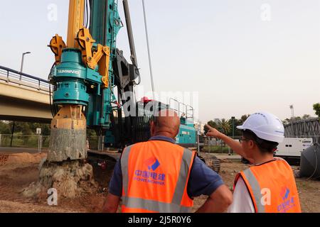 (220425) -- TEL AVIV, 25 avril 2022 (Xinhua) -- Un constructeur chinois et un collègue israélien travaillent sur le site de construction de la ligne verte du rail léger de tel Aviv, dans le nord de tel Aviv, Israël, le 24 avril 2022. La construction d'un tronçon de la ligne verte du rail léger de tel Aviv a débuté dimanche, comprenant la station de lecture et un pont au-dessus de la rivière Yarkon. Le projet, entrepris par Power Construction Corporation of China (PCCC), devrait s'achever en 2024 avec un pont de 700 mètres de long et de 13 mètres de large, ainsi qu'une station couvrant environ 2 400 mètres carrés. (Xinhua/Wang Zhuolun) Banque D'Images